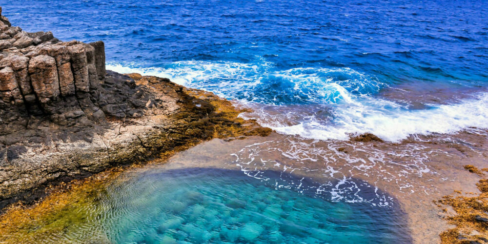 alto-angolo-di-ripresa-di-un-bellissimo-mare-circondato-da-formazioni-rocciose-nelle-isole-canarie-spagna
